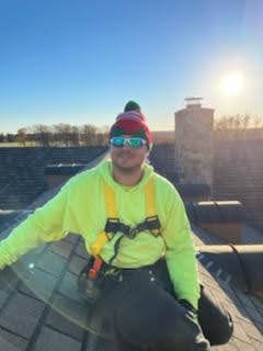 E.L.F. Designs crew member in safety gear on a rooftop during a Christmas light installation in Harford County, Maryland