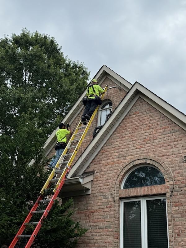 E.L.F. Designs two-man crew on ladders installing Christmas lights on a brick home in Fallston, Maryland
