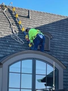 E.L.F. Designs technician installing holiday lights on a steep roofline in Bel Air, Maryland