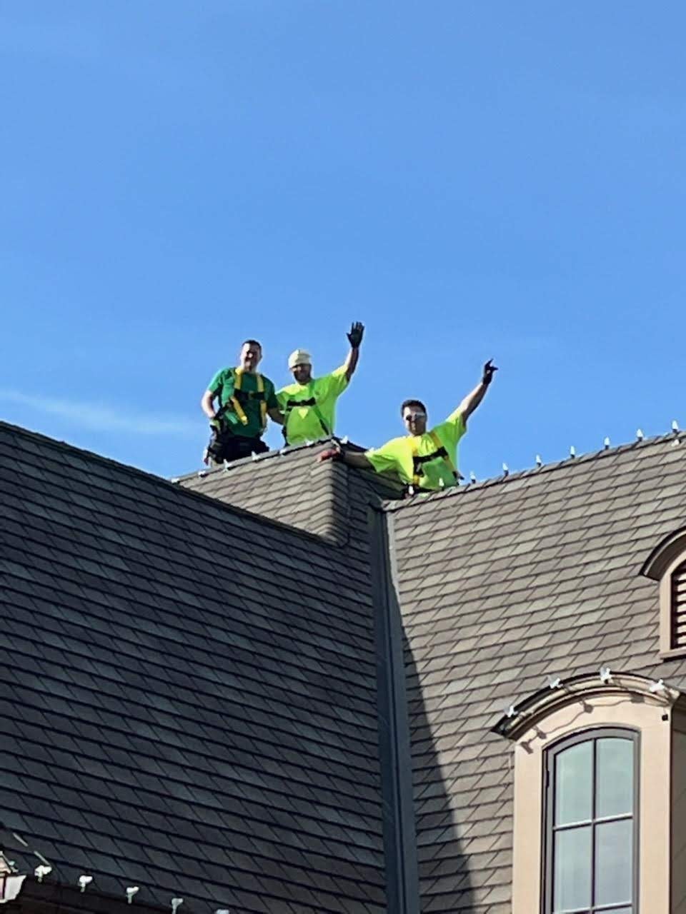E.L.F. Designs crew celebrating on a rooftop after completing a Christmas light installation in Bel Air, Maryland
