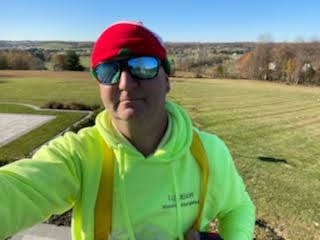 E.L.F. Designs crew member on a rooftop with a scenic view during a lighting installation in Fallston, Maryland